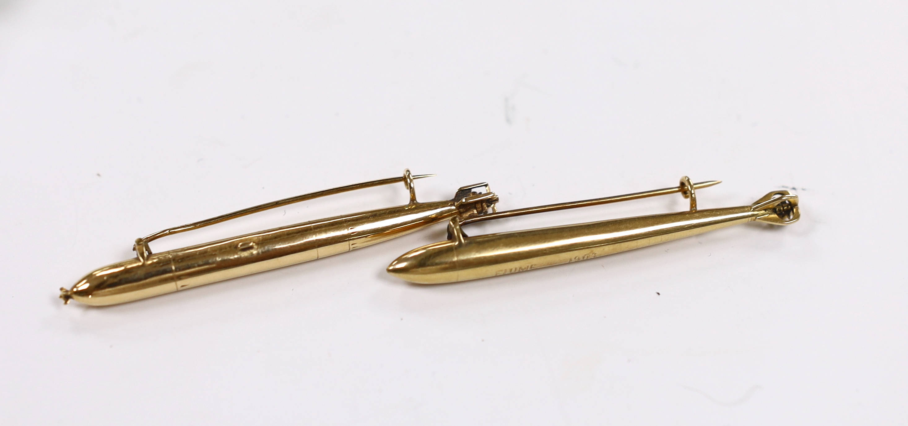 Two early 20th century yellow metal torpedo brooches, one inscribed 'Fiume 1903 Klara', 62mm et infra, 5.6 grams.